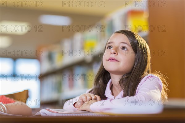 Mixed race student sitting at desk in library