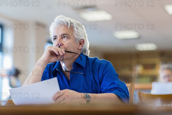 Man reading paperwork in library