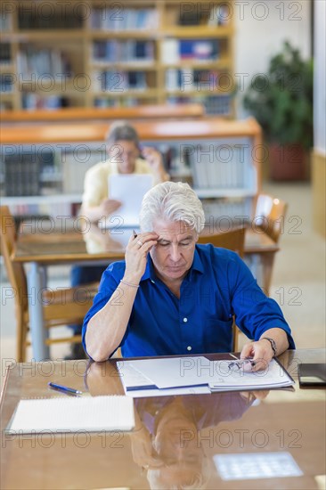 Man reading paperwork in library