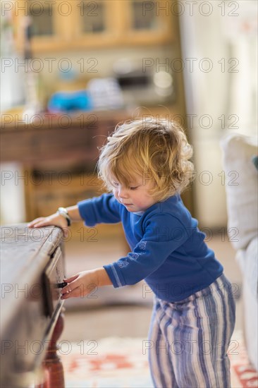 Caucasian baby opening coffee table drawers