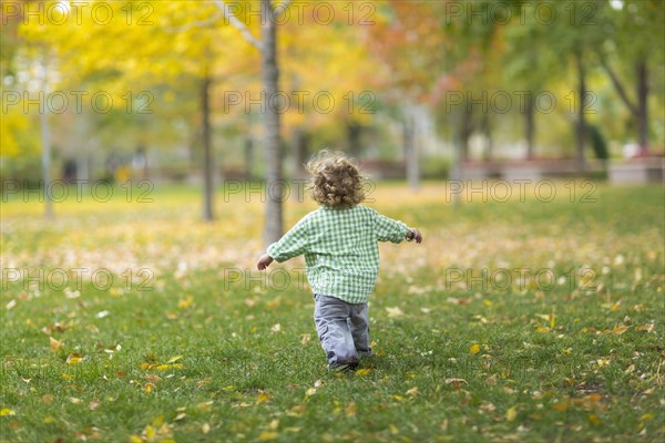 Caucasian boy running on grass lawn