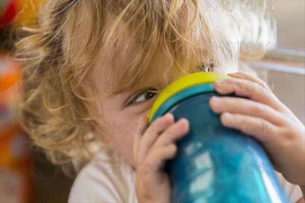 Caucasian baby drinking water from cup