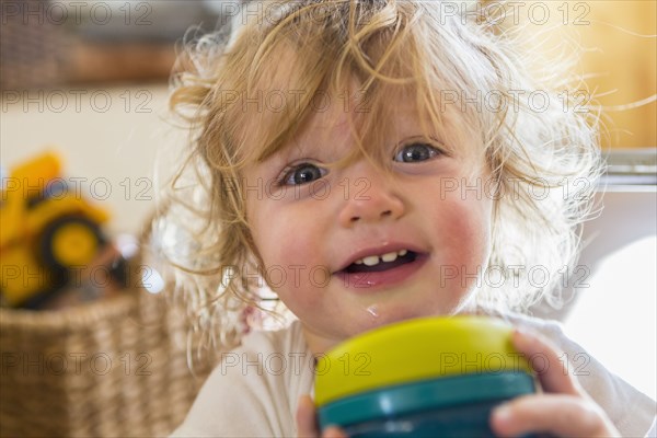 Caucasian baby holding cup