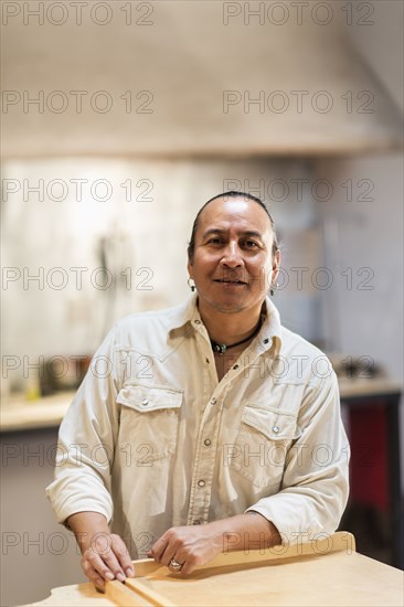 Native American man leaning on table