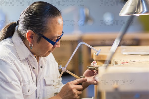 Native American jeweler working in studio