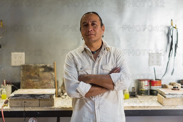 Native American jeweler standing in studio