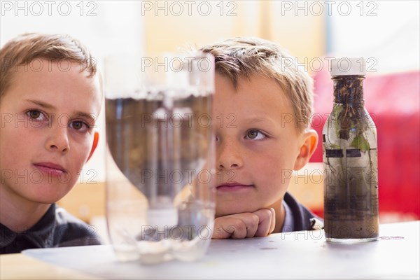 Students examining bottles in classroom