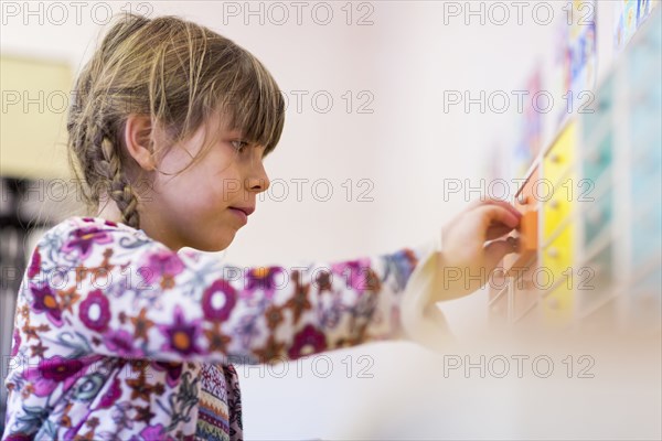 Close up of mixed race girl opening drawer in classroom