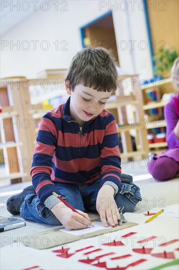 Caucasian boy drawing in classroom