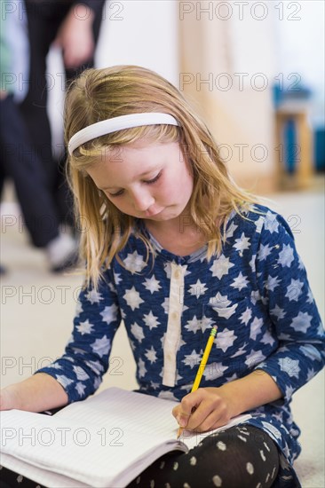 Caucasian girl writing in classroom