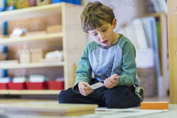 Boy thinking on floor in classroom