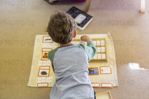Caucasian boy arranging cards in classroom