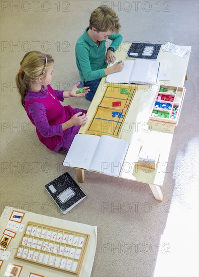 Caucasian children at table in classroom