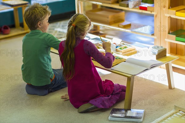 Caucasian children at table in classroom