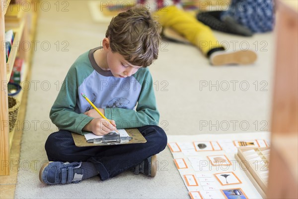 Boy writing in classroom