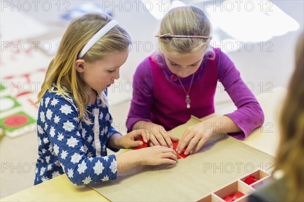 Caucasian girls working together in classroom