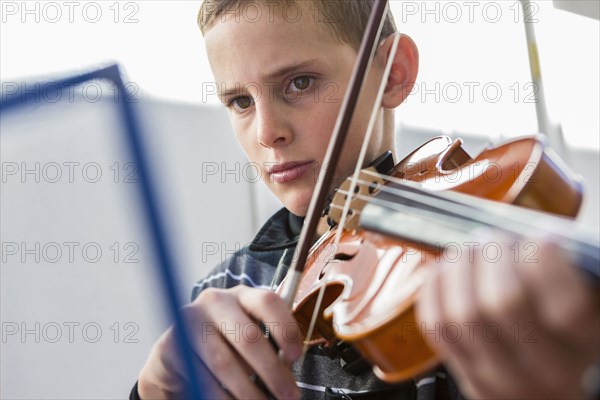 Close up of Caucasian boy playing violin