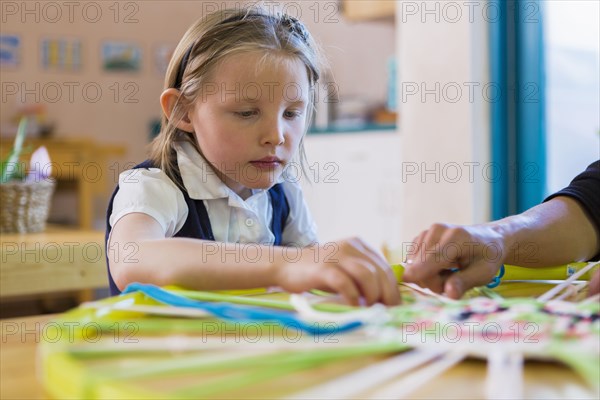 Montessori teacher helping student in classroom