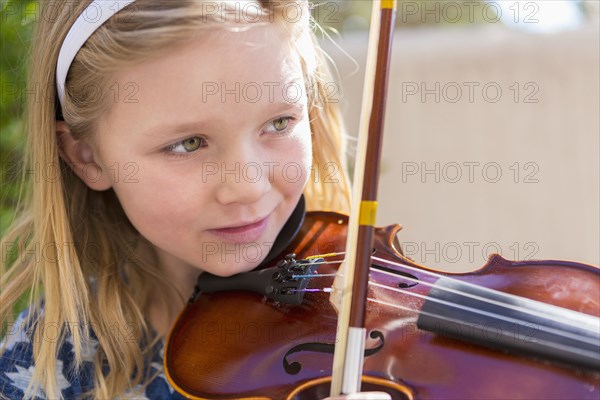 Close up of Caucasian girl playing violin