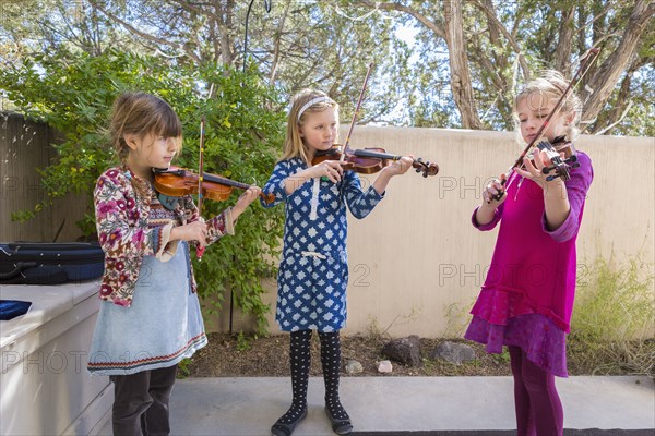 Girls playing violin outdoors