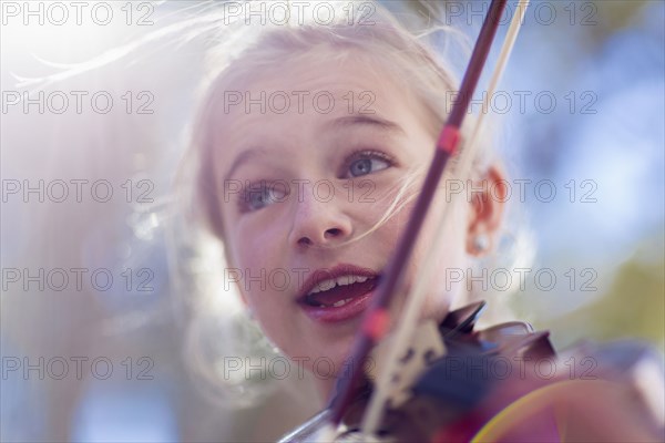 Close up of Caucasian girl playing violin