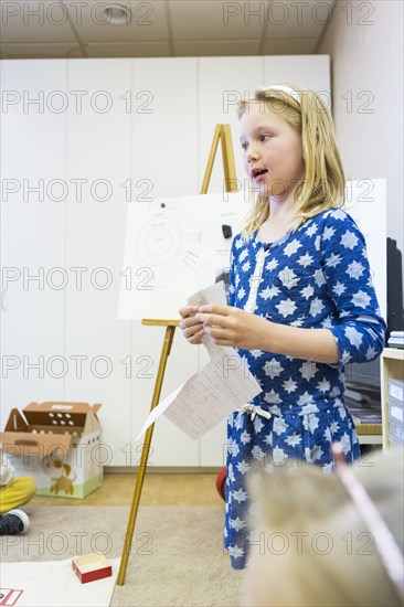 Caucasian girl giving presentation to classmates