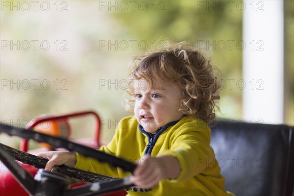 Caucasian baby boy driving tractor