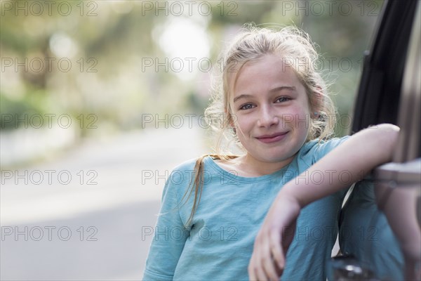 Caucasian girl leaning on car