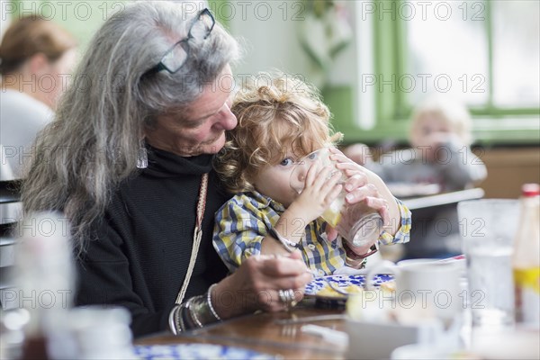 Caucasian grandmother and grandson eating dinner in restaurant