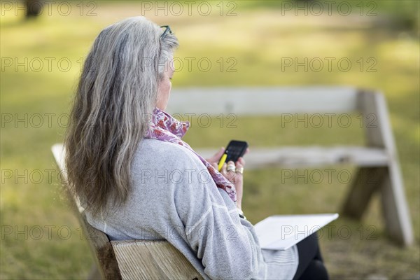 Older Caucasian woman using cell phone outdoors