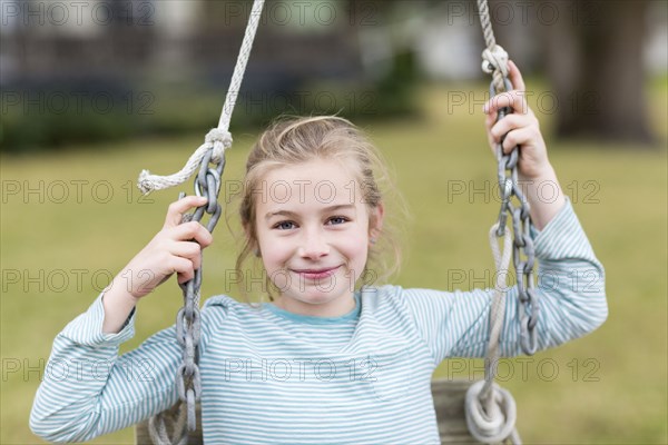 Caucasian girl smiling in swing