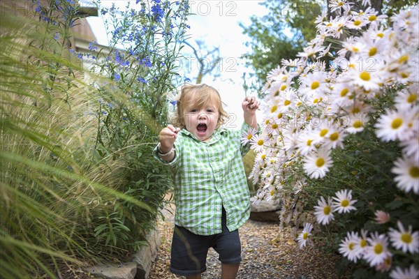 Caucasian baby boy walking in garden