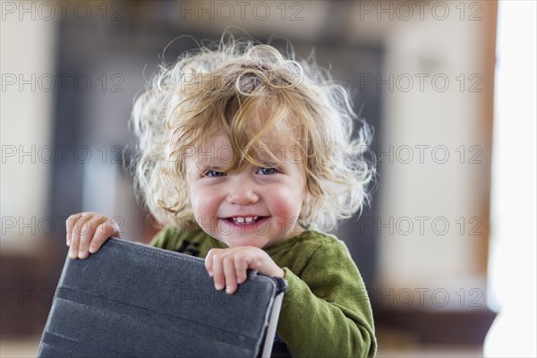 Caucasian baby boy holding digital tablet