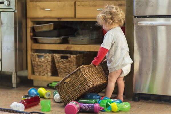 Caucasian baby boy playing with toys and basket