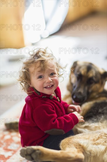 Caucasian baby boy playing with dog on floor