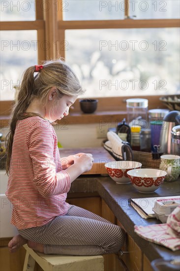 Caucasian girl cooking in kitchen