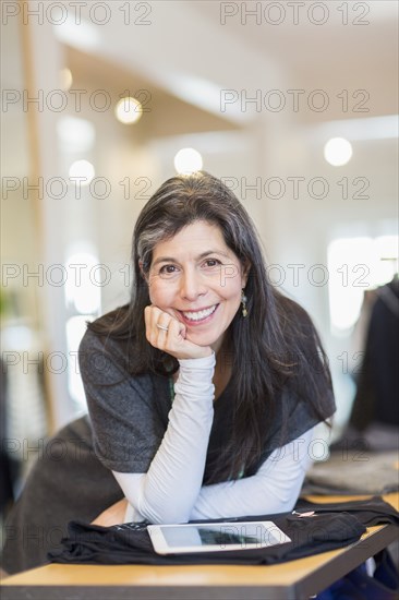 Hispanic small business owner using digital tablet in store