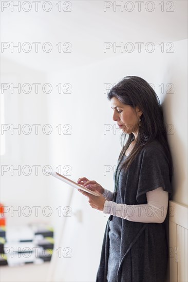 Hispanic small business owner using digital tablet in store