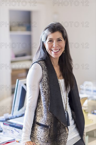 Hispanic businesswoman smiling in office