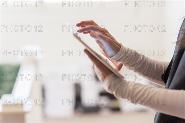 Close up of Hispanic businesswoman using digital tablet