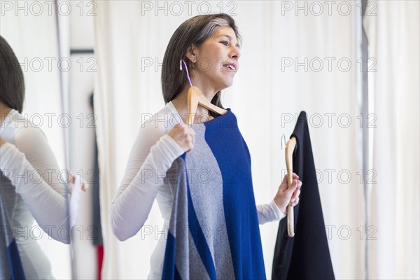 Hispanic woman browsing clothing in store