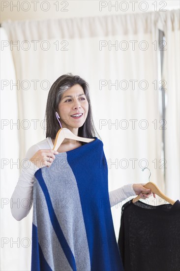 Hispanic woman browsing clothing in store