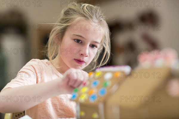 Caucasian girl decorating gingerbread house
