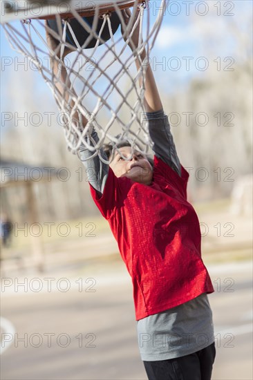 Caucasian boy playing basketball on court