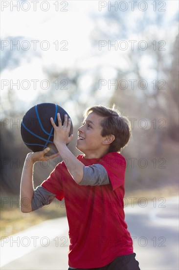 Caucasian boy playing basketball on court