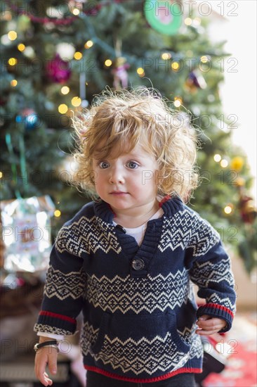 Caucasian baby boy decorating Christmas tree