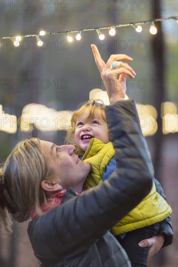 Caucasian mother and son admiring string lights