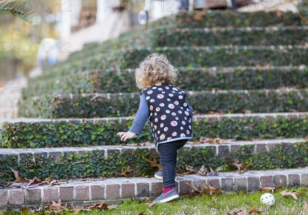 Caucasian baby boy climbing staircase