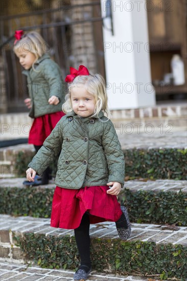 Caucasian girls in holiday dresses on steps