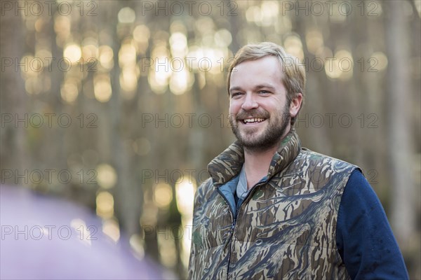 Caucasian man wearing camouflage vest outdoors